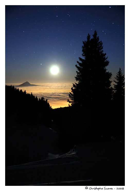 Paysage des Alpes la nuit - Mer de nuage claire par la lune et les lumires de Cluses et des Carroz sur la valle le L'Arve. Le Mle (1860m) est  peine visible.