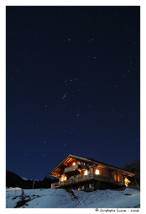 Paysage des Alpes la nuit - Chalet sous un ciel toil dans le massif du Beaufortain. On reconnait la constellation d'Orion.